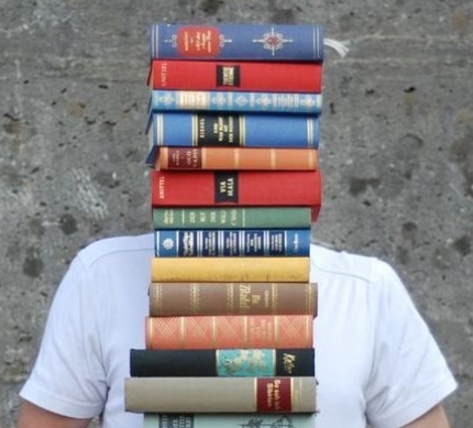 Mensch mit Bücherstapel